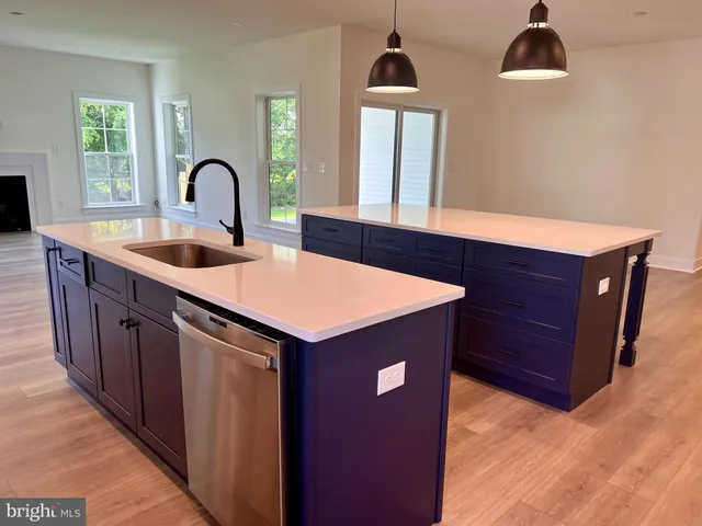 a kitchen with stainless steel appliances granite countertop a sink a stove and a wooden floors