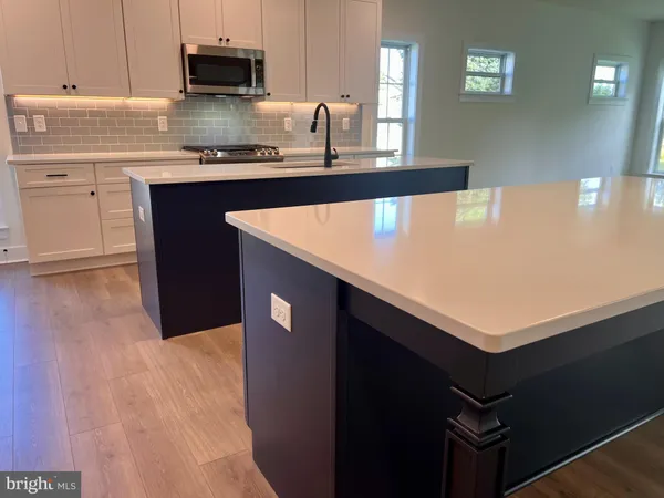 a kitchen with kitchen island a sink a stove and wooden floor