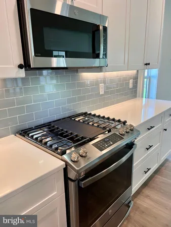 a stove top oven sitting inside of a kitchen