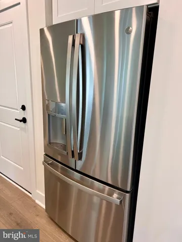 an empty refrigerator with wooden floor