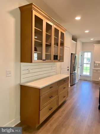 a kitchen with a stove and wooden floor