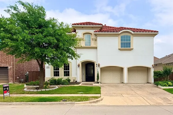 a front view of a house with a garden and plants
