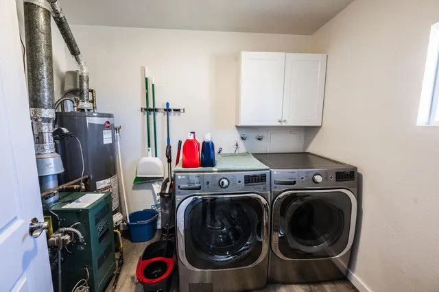 a utility room with dryer washer and a view of living room