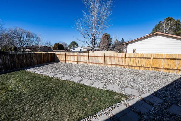 a view of backyard with wooden fence