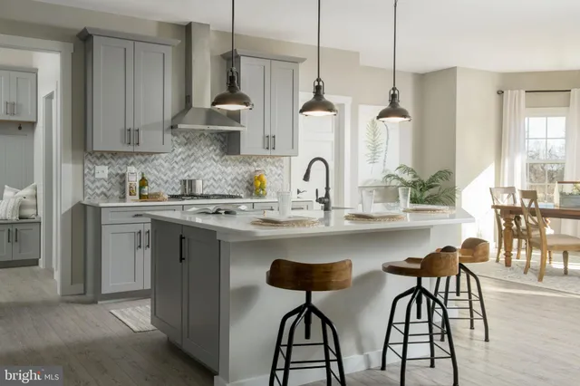 a kitchen with stainless steel appliances a sink a stove a dining table and chairs