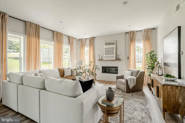 a living room with furniture fireplace and a large window