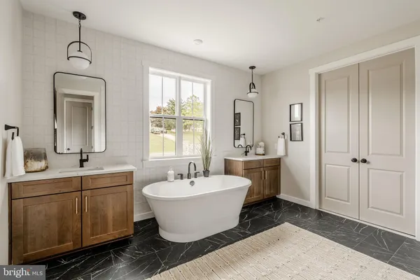 a view of a bathroom with 2 sink mirror and window