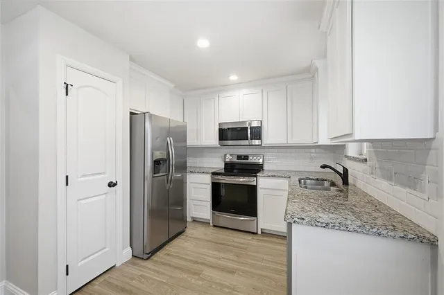 a kitchen with stainless steel appliances granite countertop a refrigerator stove and sink