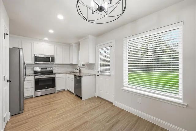a kitchen with a refrigerator cabinets and wooden floor