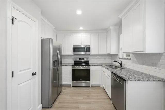 a kitchen with stainless steel appliances granite countertop a refrigerator and a stove top oven