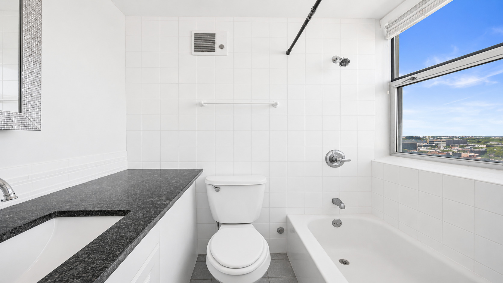 3110 North Sheridan Road, Unit 1807 Chicago, IL 60657 - Photo 14 of 21 a bathroom with a granite countertop bathtub sink vanity mirror and toilet