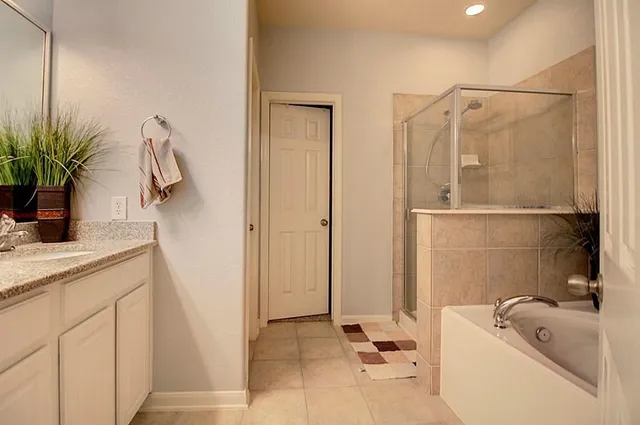 a bathroom with a tub a sink and mirror