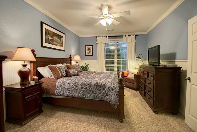 a spacious bedroom with a bed and a flat screen television