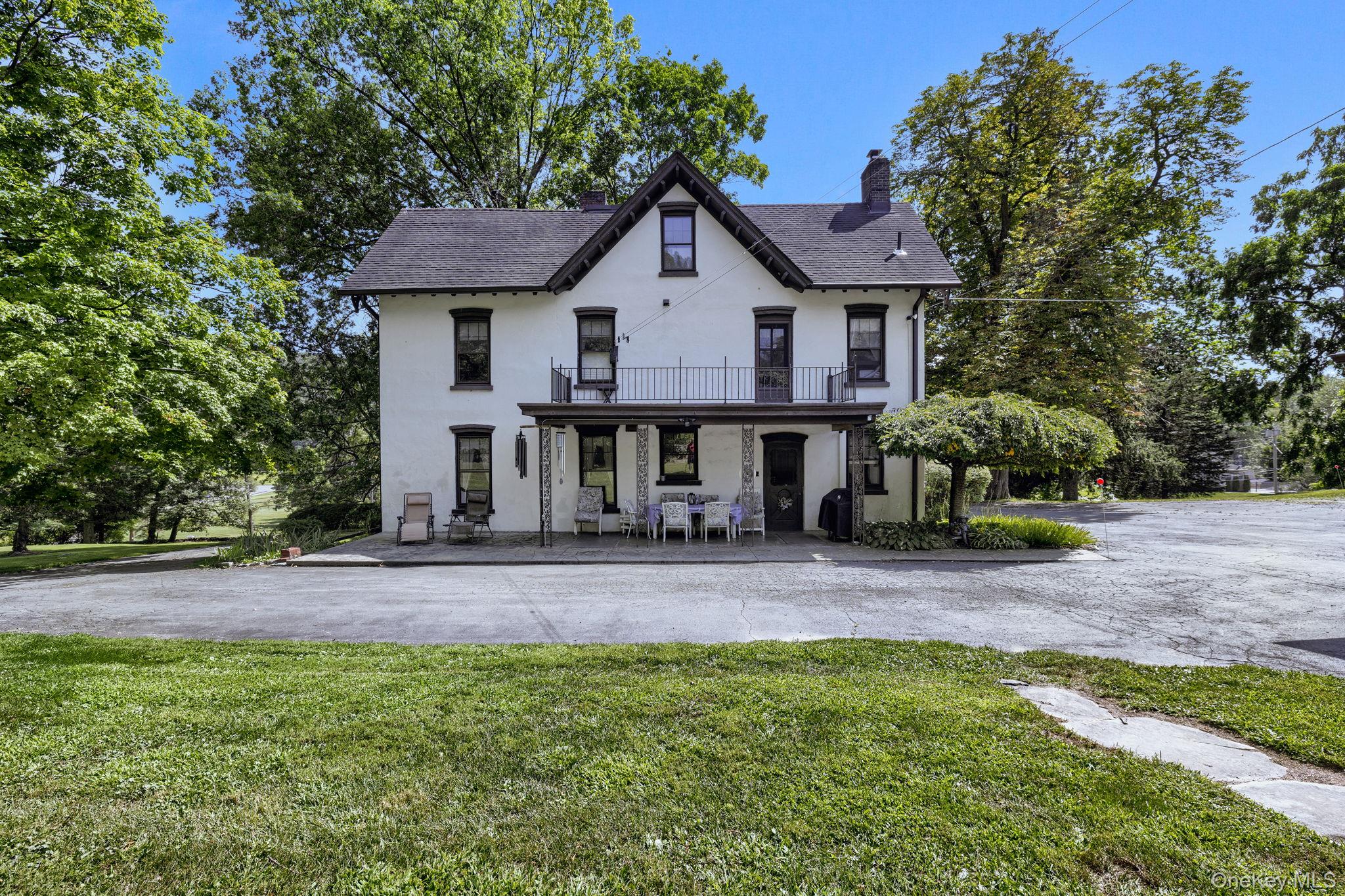 470 Little Britain Road Newburgh, NY 12550 - Photo 43 of 45 View of front facade with stucco siding, a chimney, a front yard, and a shingled roof