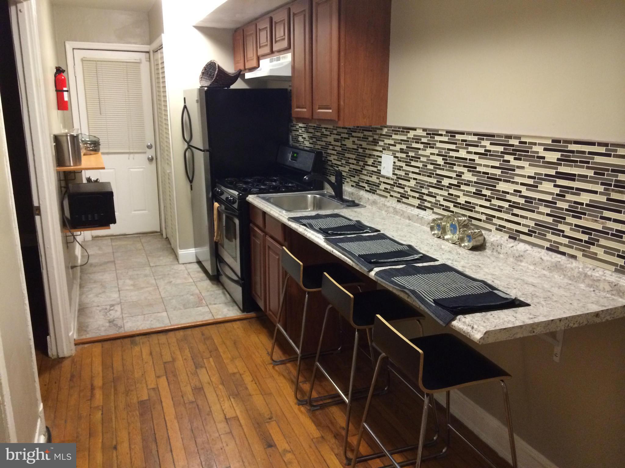 1226 Simms Place Northeast Washington, DC 20002 - Photo 11 of 15 a kitchen with granite countertop a stove and a refrigerator