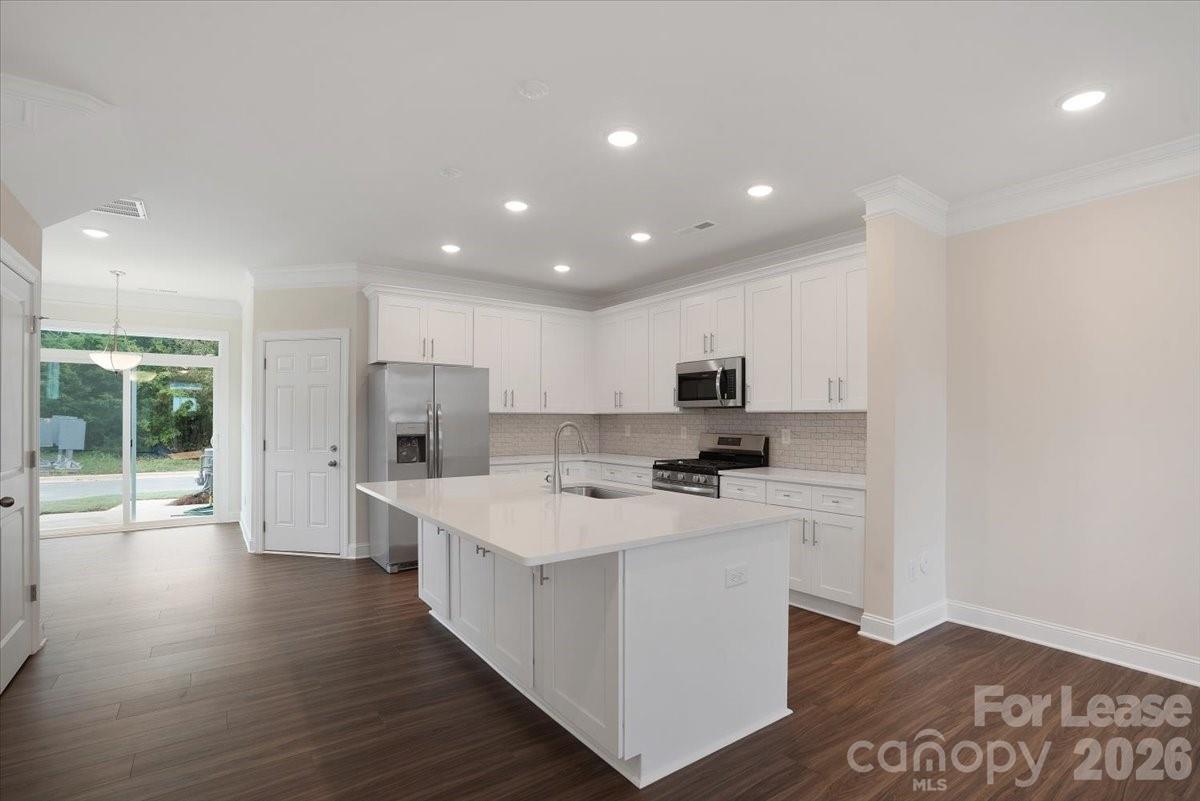 5569 Stafford Road Charlotte, NC 28215 - Photo 9 of 29 a kitchen with stainless steel appliances a sink a stove a refrigerator and a microwave