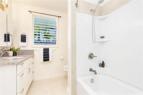 a bathroom with a tub sink and mirror