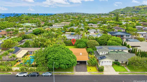 an aerial view of residential houses with outdoor space and trees