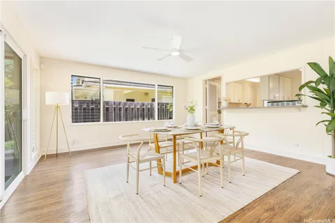 a dining room with wooden floor and a floor to ceiling window