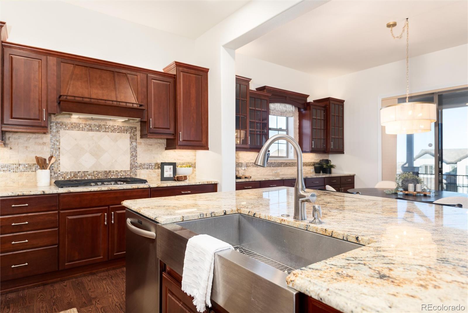 10698 Mountaingate Court Highlands Ranch, CO 80126 - Photo 13 of 47 a kitchen with stainless steel appliances granite countertop a sink stove and cabinets