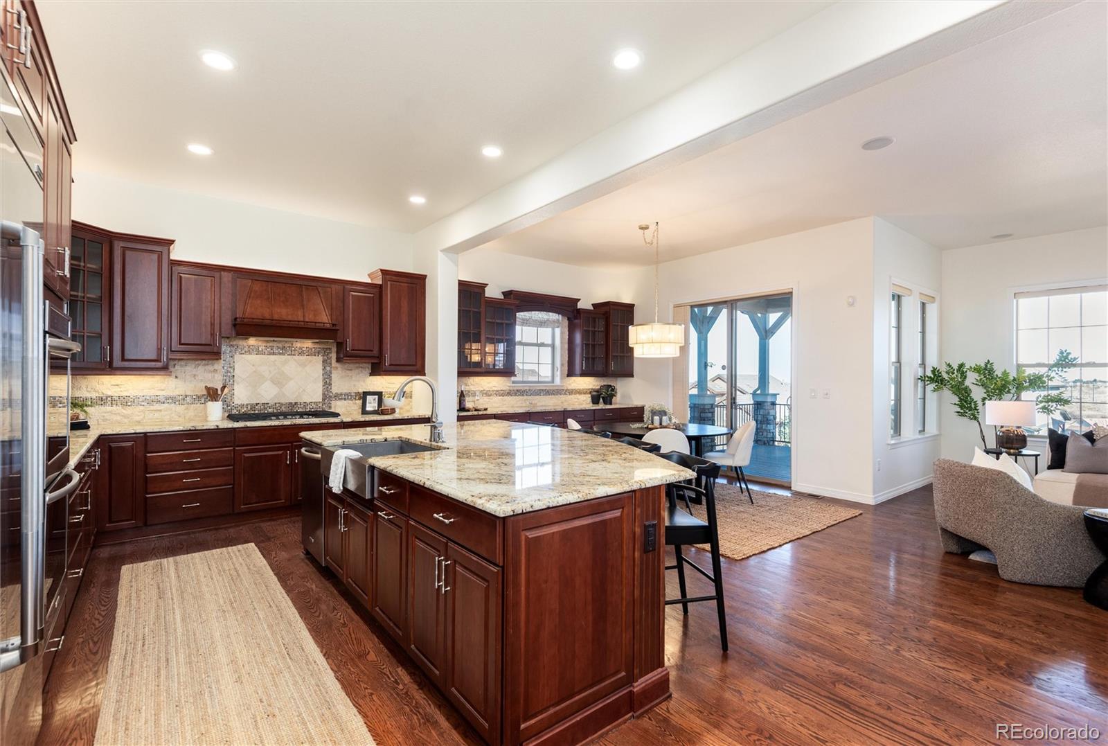 10698 Mountaingate Court Highlands Ranch, CO 80126 - Photo 17 of 47 a large kitchen with stainless steel appliances and wooden cabinets