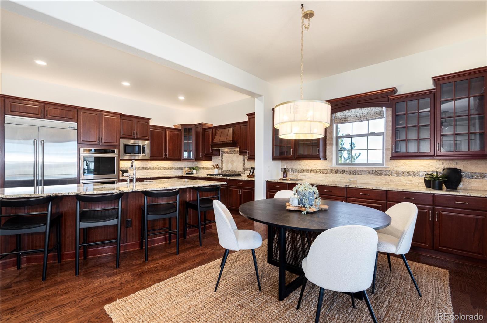 10698 Mountaingate Court Highlands Ranch, CO 80126 - Photo 19 of 47 a kitchen with granite countertop a dining table chairs workspace and a window