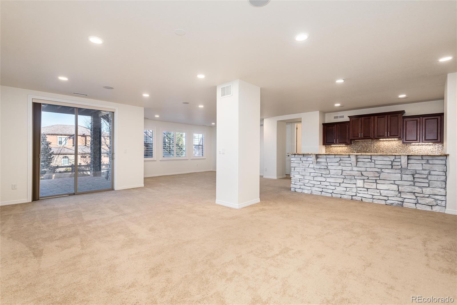 10698 Mountaingate Court Highlands Ranch, CO 80126 - Photo 31 of 47 a view of an empty room with a fireplace and a projector