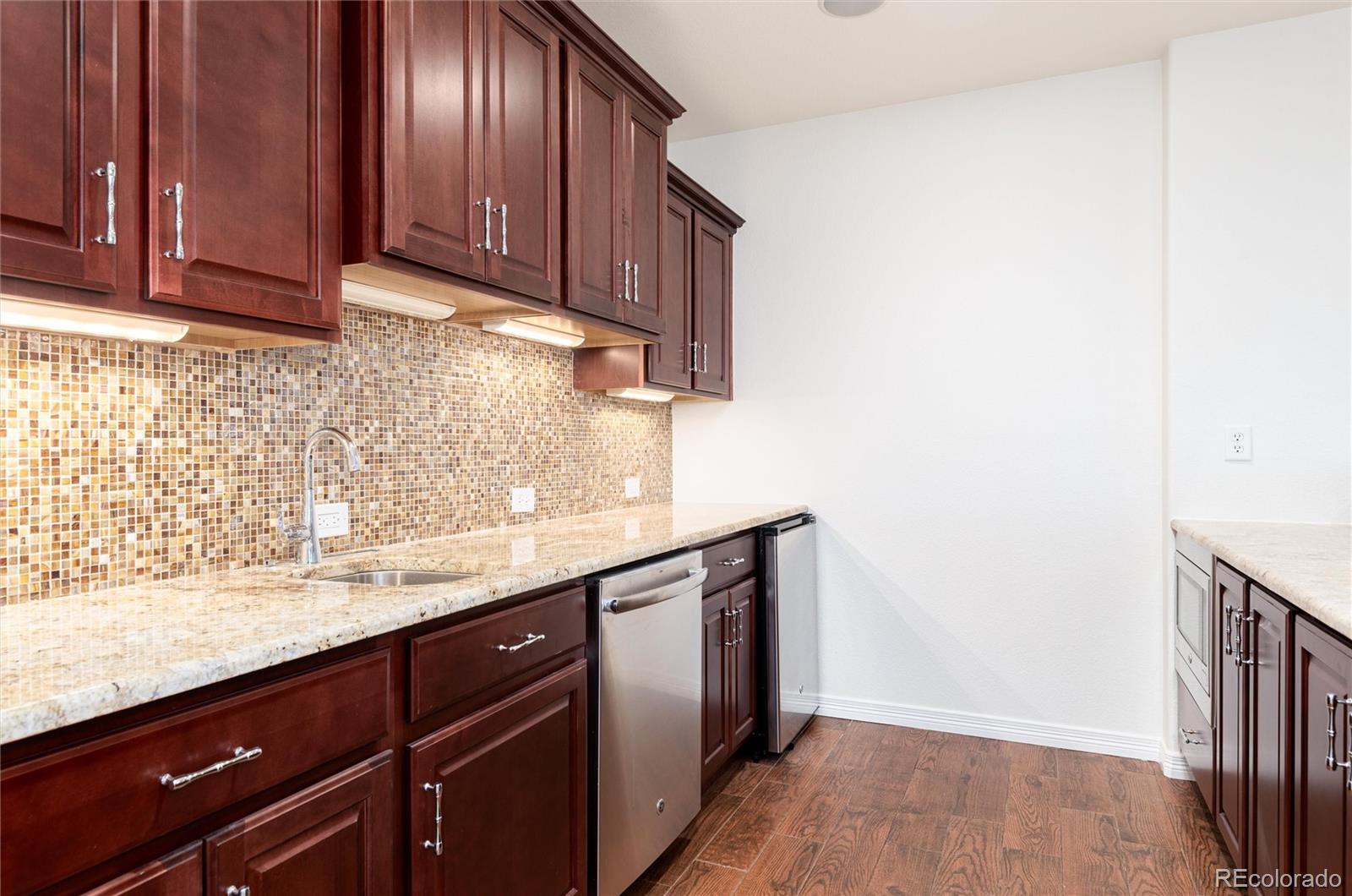 10698 Mountaingate Court Highlands Ranch, CO 80126 - Photo 32 of 47 a view of a kitchen with stainless steel appliances granite countertop wooden cabinets and a counter top space