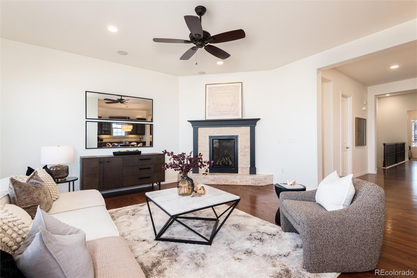 10698 Mountaingate Court Highlands Ranch, CO 80126 - Photo 7 of 47 a living room with furniture a fireplace and a flat screen tv