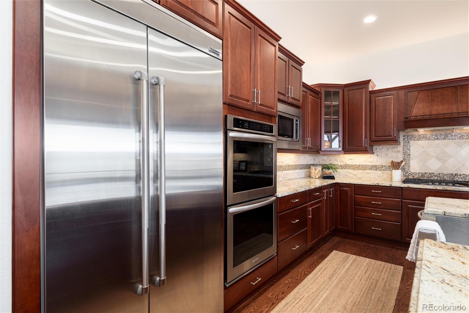 10698 Mountaingate Court Highlands Ranch, CO 80126 - Photo 10 of 47 a kitchen with stainless steel appliances granite countertop a refrigerator and a sink