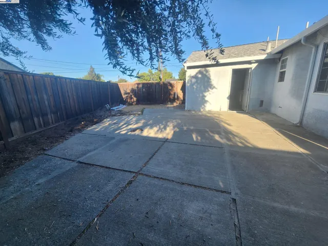 a view of backyard and wooden fence