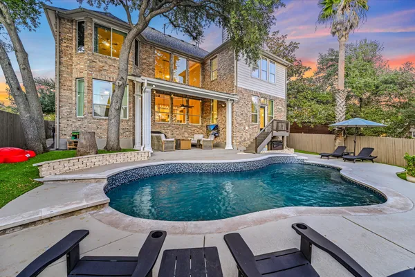 a view of a house with backyard sitting area and swimming pool