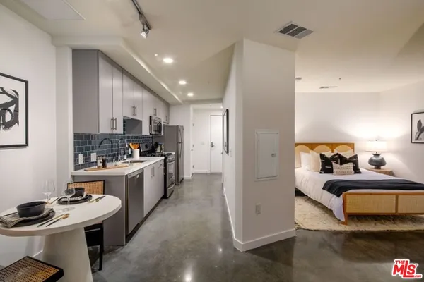 a kitchen with stainless steel appliances a sink stove refrigerator and cabinets