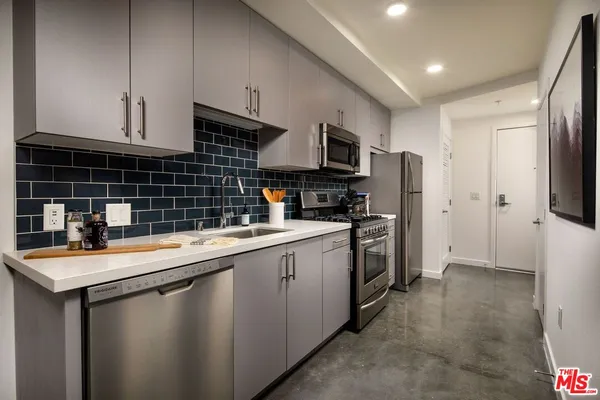 a utility room with dryer washer and a view of kitchen