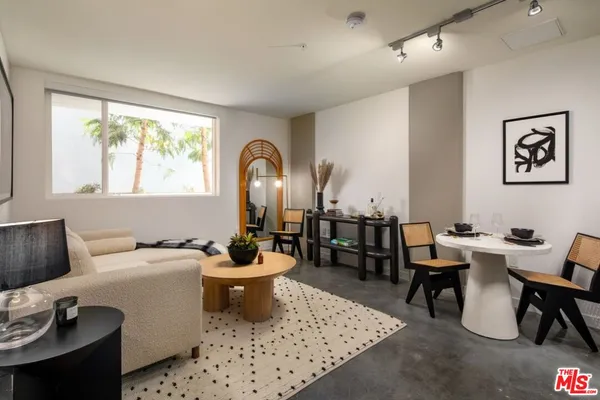 a living room with furniture a rug and white walls
