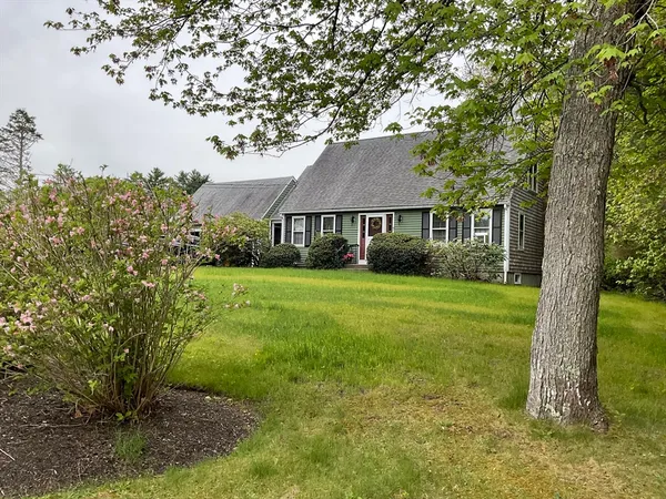 a view of house in front of a big yard with large trees