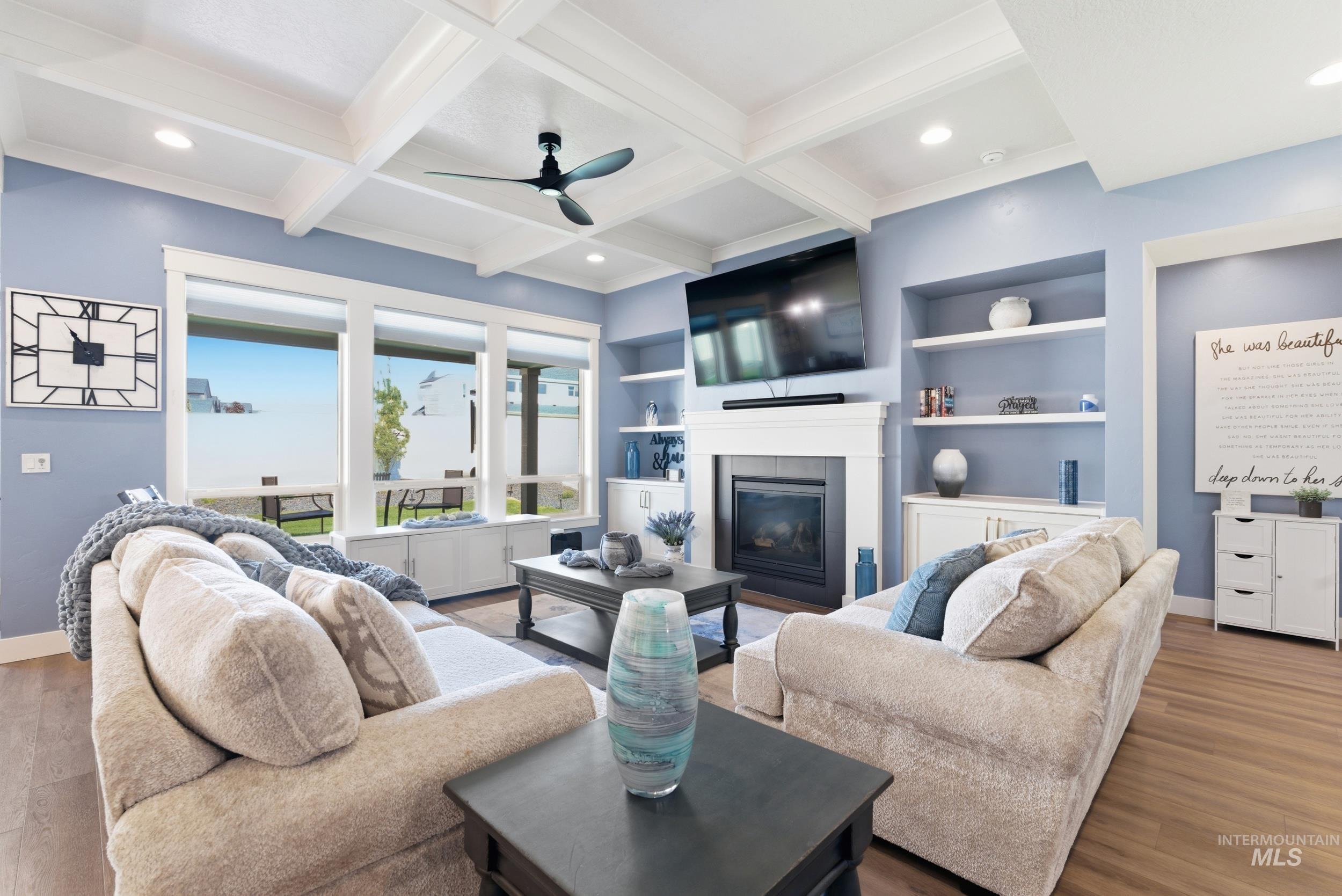 6347 South Utmost Lane Meridian, ID 83642 - Photo 3 of 37 Spacious living area featuring coffered ceilings, wood-finish flooring, a built-in fireplace with white mantel, and built-in shelving