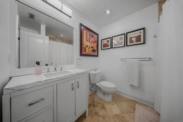 a bathroom with a toilet sink and mirror