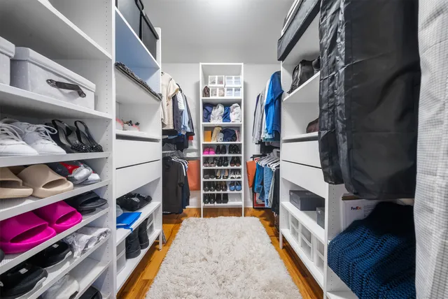 a view of walk in closet with clothes and shoes
