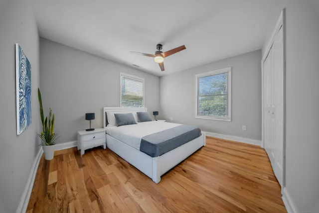 a spacious bedroom with a bed and a ceiling fan