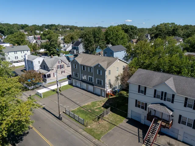 an aerial view of residential houses with outdoor space and trees