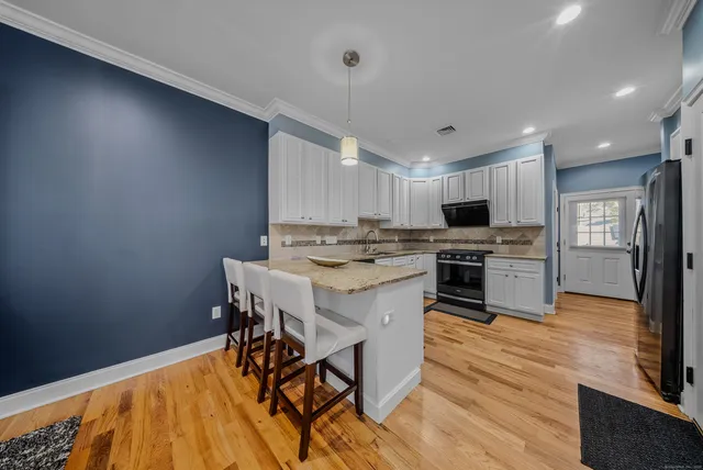 a kitchen with a table chairs microwave and cabinets