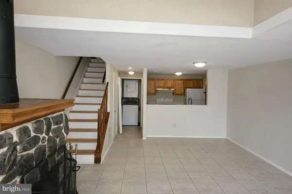 a kitchen with granite countertop a refrigerator and a stove top oven