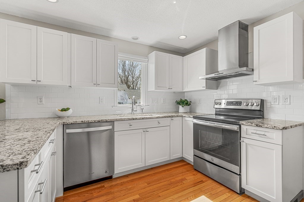 7 Coltsway, Unit 7 Wayland, MA 01778 - Photo 6 of 26 a kitchen with stainless steel appliances granite countertop a sink and cabinets with wooden floor