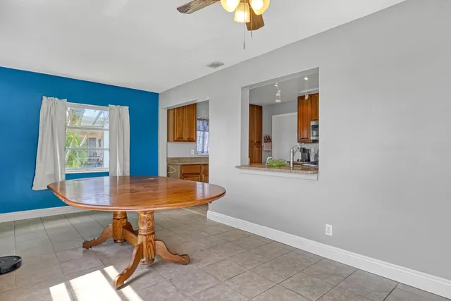 a kitchen with stainless steel appliances granite countertop a dining table and chairs