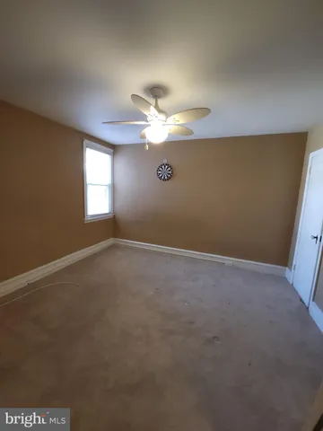 a view of empty room with window and ceiling fan