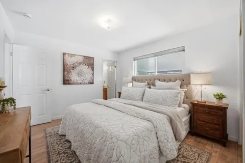 a bedroom with a bed and a painting on the wall
