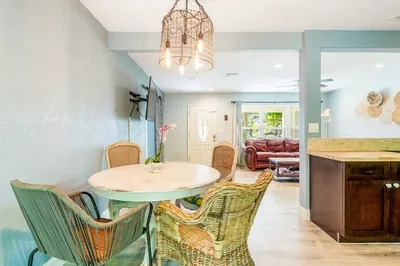 a living room with furniture a chandelier and a dining table