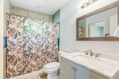 a bathroom with a granite countertop sink and a toilet