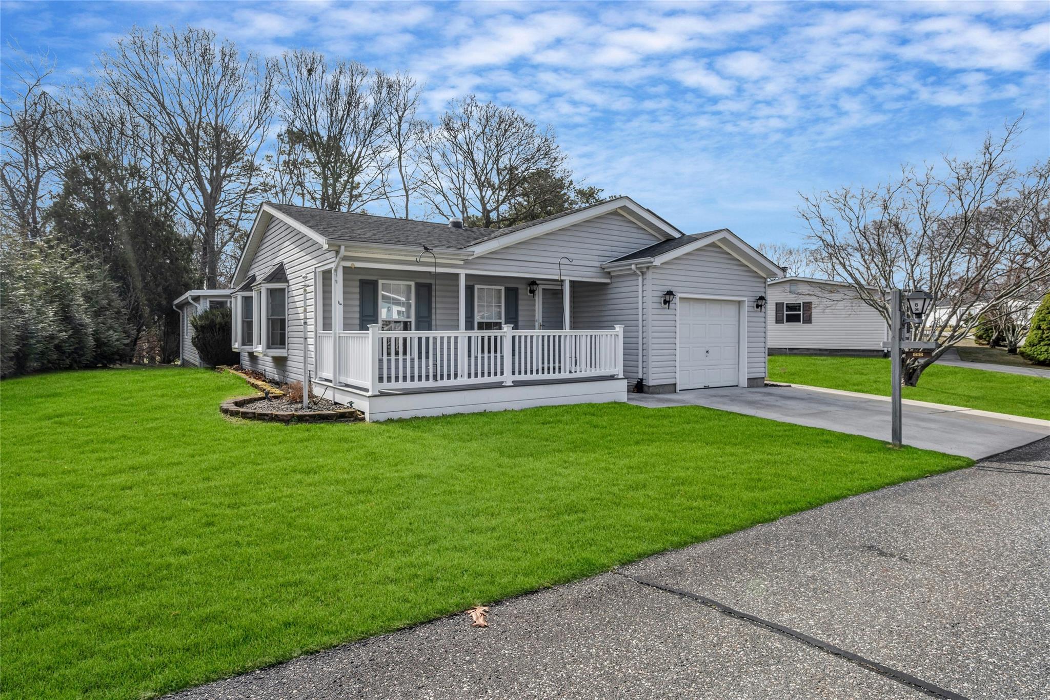 1407 Middle Road, Unit 88 Calverton, NY 11933 - Photo 1 of 1 a view of a house with a big yard plants and large trees